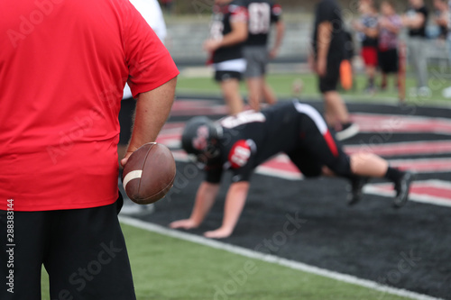 A football coach warms up his team prior to a game