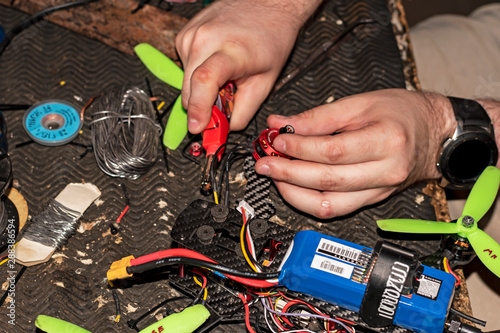 hands of man working on a DIY drone on workbench
