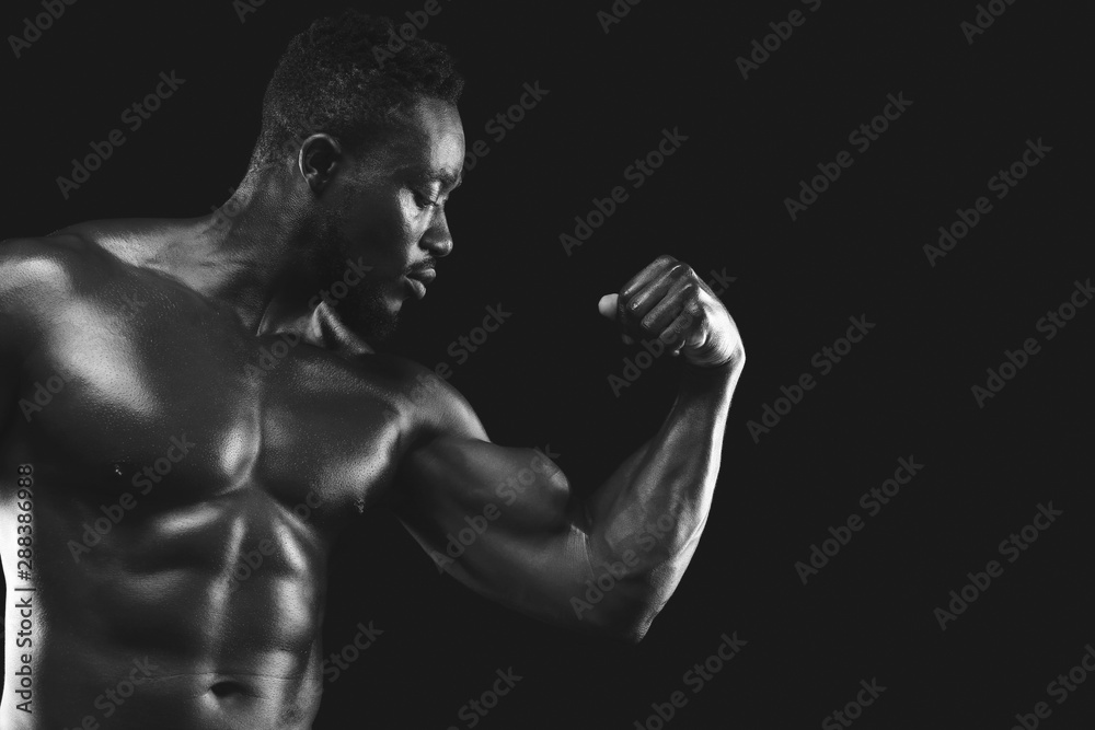 Monochrome photo of african fitness model demonstrating his strong arm