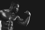 Monochrome photo of african fitness model demonstrating his strong arm