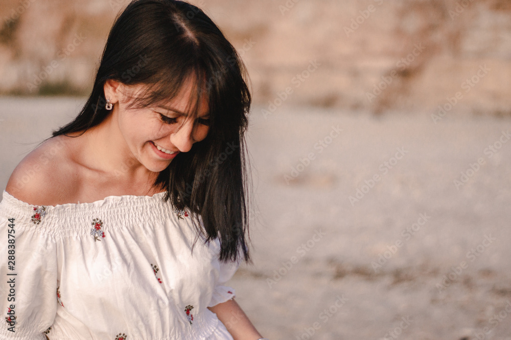 beautiful young brunete woman's hair develop in the wind on the beach. the model wearing boho style clothes, girl enjoys freedoom and sunrise beautiful young brunete woman's hair develop in the wind on the beach. the model wearing boho style clothes, girl enjoys freedoom and sunrise