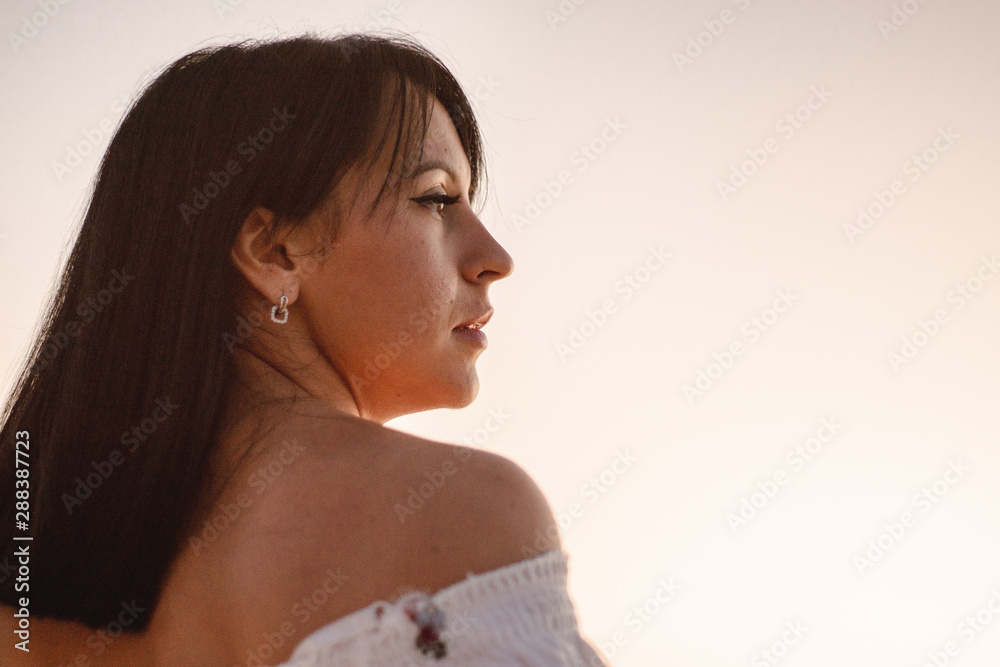 beautiful young brunete woman's hair develop in the wind on the beach. the model wearing boho style clothes, girl enjoys freedoom and sunrise beautiful young brunete woman's hair develop in the wind on the beach. the model wearing boho style clothes, girl enjoys freedoom and sunrise