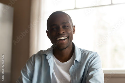 Smiling biracial male having pleasant video call