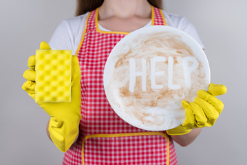 Tired of routine at home concept. Cropped close up photo of woman with crying face holding showing smeared in sauce chocolate dessert plate trying to remove the dirt isolated grey background