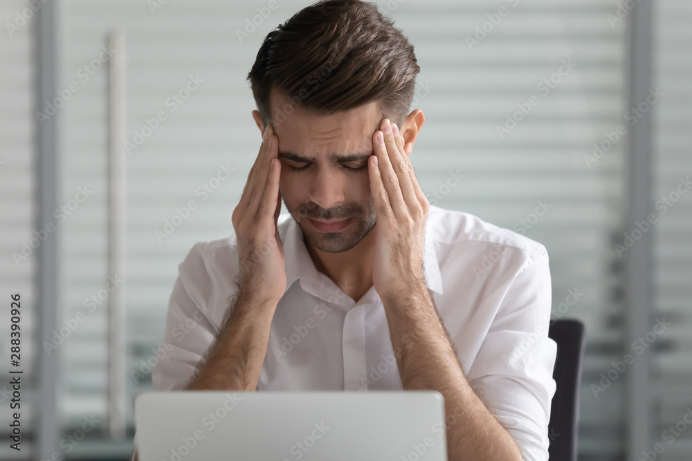 Head shot unhappy young male employee suffering from strong headache. Head shot unhappy young male employee suffering from strong headache.