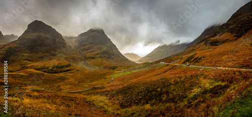 Panoramic view of bright green and orange mountains on an overcast afternoon in Glencoe, Highland, Scotland, United Kingdom
