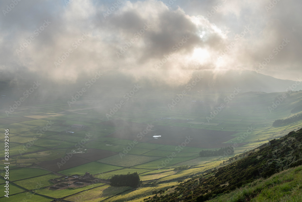 low clouds over the Miradouro da Serra do Cume revealing the typical plots with walls landscape of Terceira