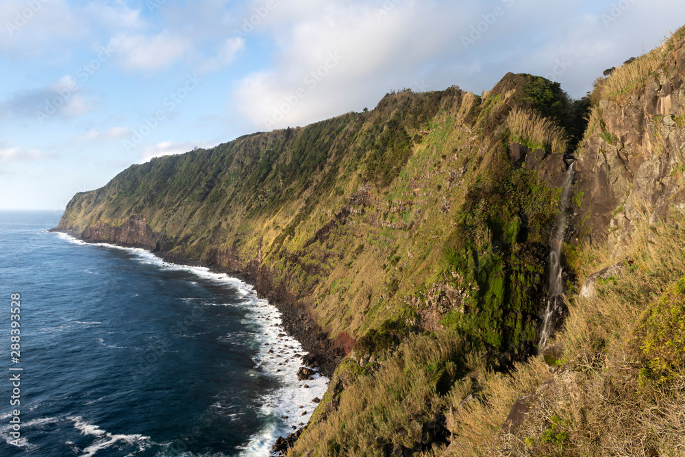 landscape image of Cascata da Ponta do Arnel waterfall showing the wild green cliffs of the eastcoast of São Miguel island on the Azores landscape image of Cascata da Ponta do Arnel waterfall showing the wild green cliffs of the eastcoast of São Miguel island on the Azores