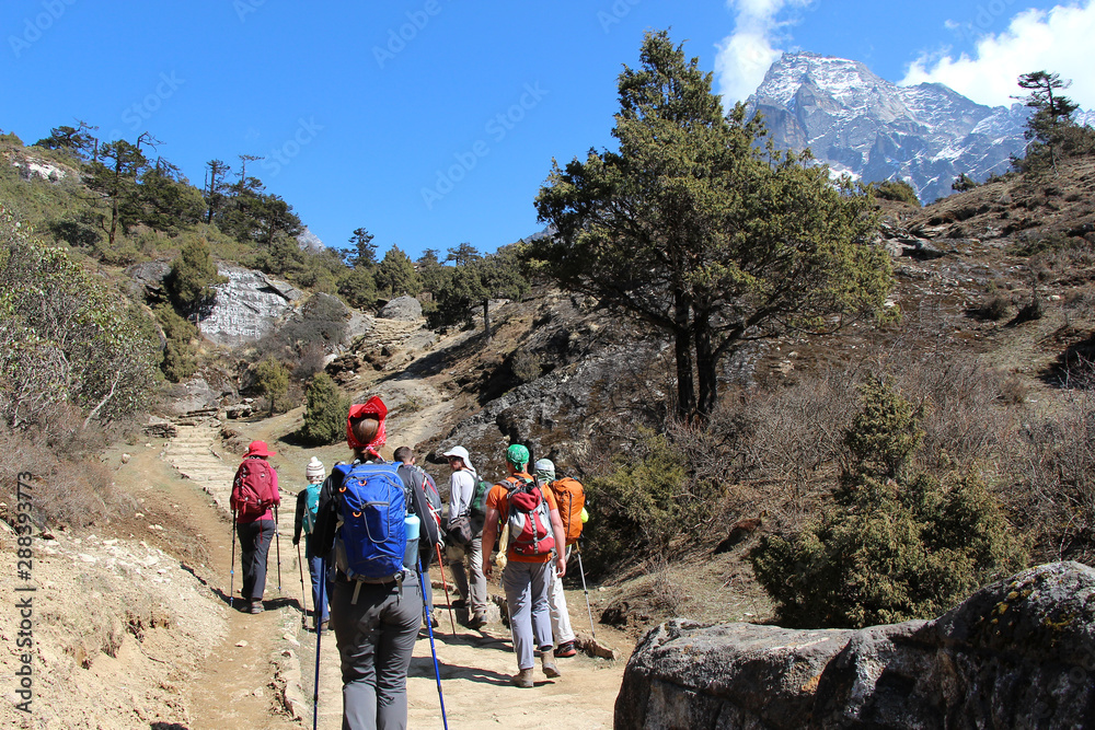 Travelers follows the route towards Khumbila Mountain in Sagarmatha national park in Nepal. Nature, people, healthy lifestyle, outdoors, altitude sickness, travel and tourism concept.