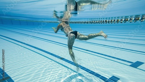 Woman swimming in the poolin the olympic Swimming pool view from under water photo