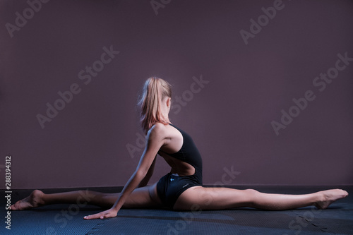 A girl in a black bathing suit sits on a twine. Fortography in a vein.