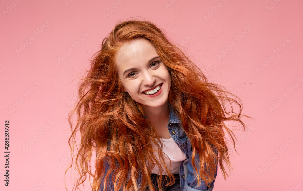 Fototapeta premium Beautiful redhead girl smiling and looking at camera