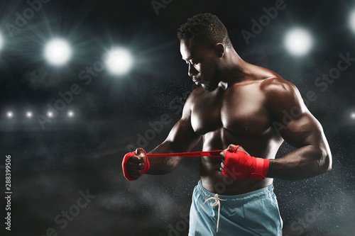Professional african american boxer wrapping hands before fight © Prostock-studio