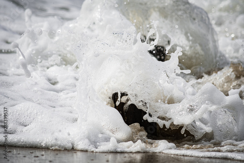 Close-up of Foamy Water Splashing onto Shore © Julio