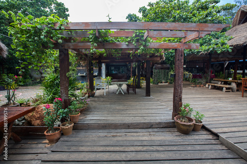 a wooden pergola, designed in Thai style, with flowers and tropical fruit, Thailand