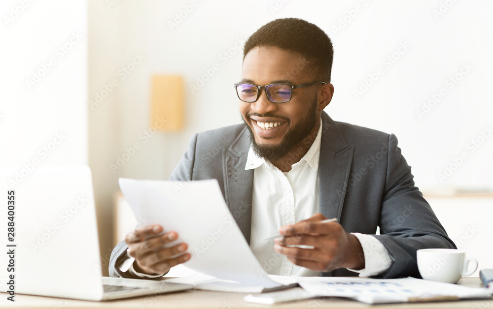 Handsome african american entrepreneur working with documents in office Handsome african american entrepreneur working with documents in office