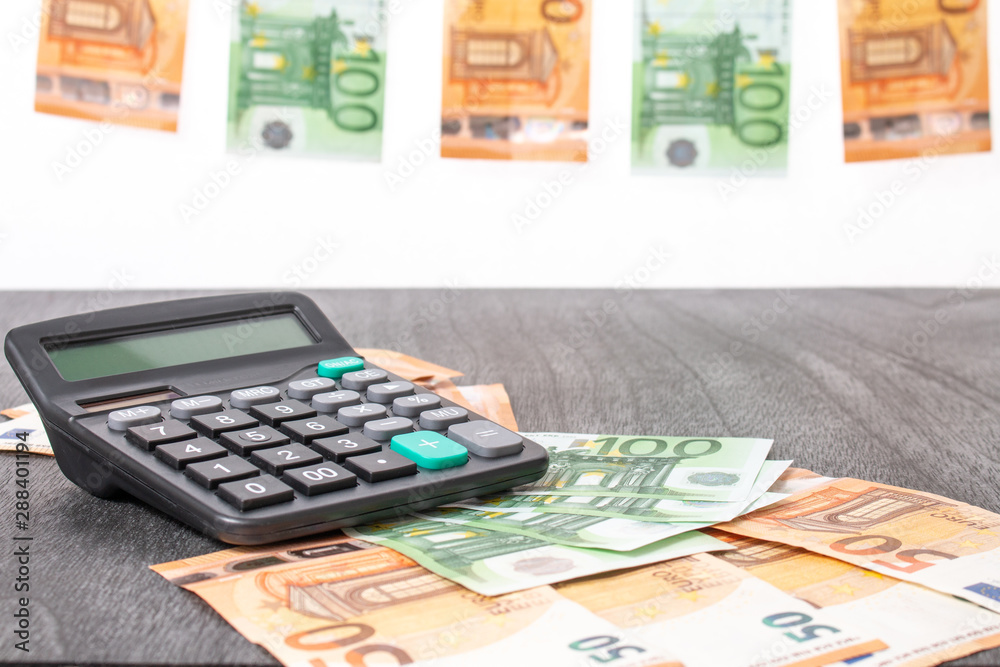 Euro banknotes hanging on a clothesline. Euro money and calculator. on Grey wooden background. Euro money with red clothes pegs on rope. Money Laundering euro hung out to dry. Copy space for text. Euro banknotes hanging on a clothesline. Euro money and calculator. on Grey wooden background. Euro money with red clothes pegs on rope. Money Laundering euro hung out to dry. Copy space for text.