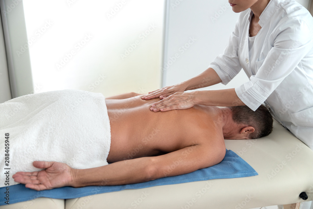 Fototapeta premium Masseur rubbing the back of a patient