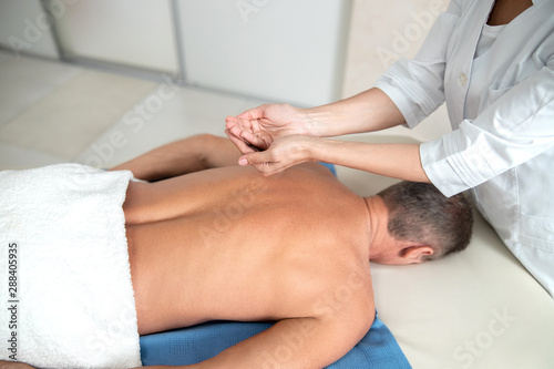 Doctor holding massage oil in his hands