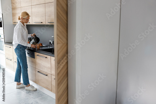 Pretty lady is standing in the kitchen