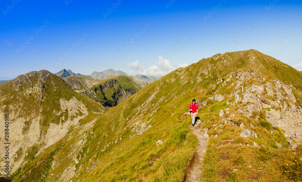 woman walking in mountain path landscape. Fagaras, Romania