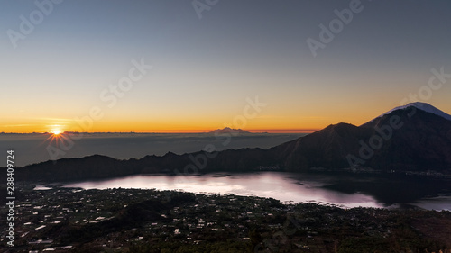 Stunning Sunrise from the top of Mt. Batur, Bali, Indonesia. In the right, across lake Batur, Mt Abang and Mt Agung. Central in the background, some peaks of Lombok.