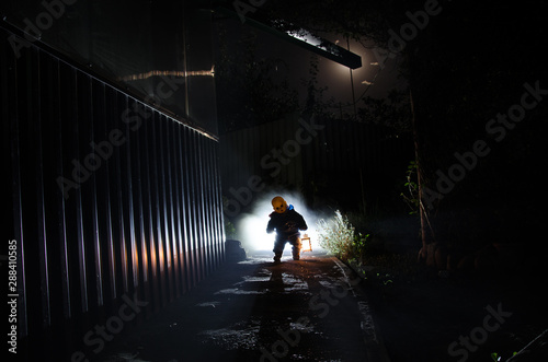 Horror scene of a scary children s ghost  Silhouette of scary baby doll on dark foggy background with light.