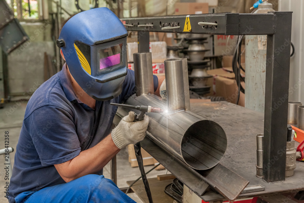 Closeup of man wearing mask welding in a workshop Closeup of man wearing mask welding in a workshop