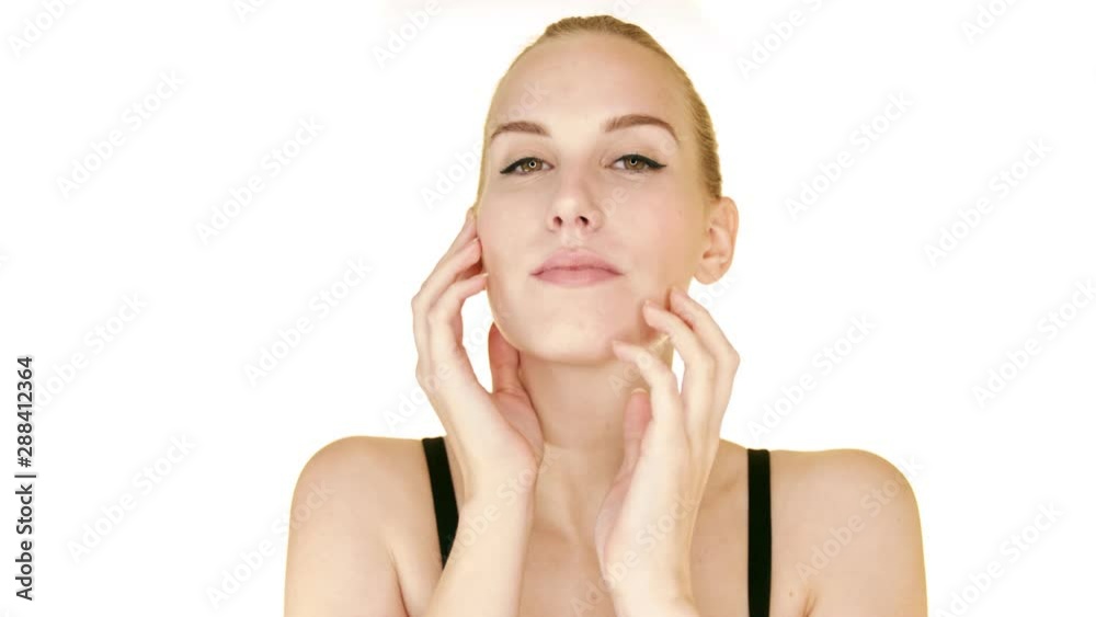 Woman with bun running her hands gently over her face. Static Woman with bun running her hands gently over her face. Static