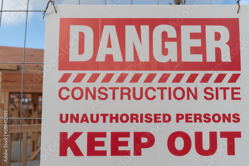 Sign at Construction Site - Danger Unauthorised Persons Keep Out, with Building in Background, in Auckland New Zealand