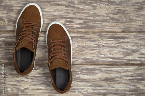 Pair of brown shoes with copy space on wooden background
