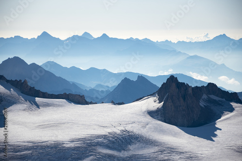 Sea of mountains and snow, blue cliff waves. Majestic view from Agui du Midi of Mont Blanc massif in summer. Chamonix, Alps, France. Eco planet and wanderlust concepts. Nature beauty background.  photo