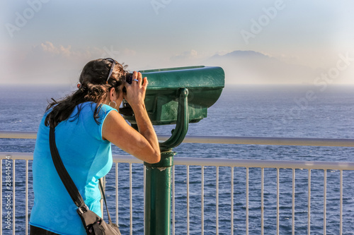 Woman looking though telescope to Africa