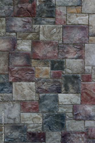 Colorful modern marble-like tile wall texture with blocks in varying hues of rose red, blue, and gray