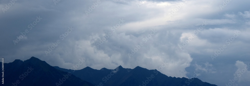 Bergkamm der Alpen mit dunklen bedrohlichen Gewitterwolken - Wettereinbruch in den Bergen Bergkamm der Alpen mit dunklen bedrohlichen Gewitterwolken - Wettereinbruch in den Bergen