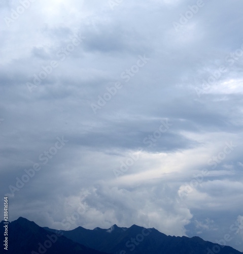 Düstere graue Regenwolken über den Alpen