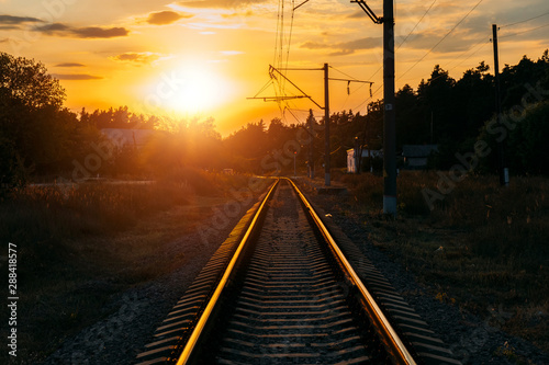 Empty railway track in sunny summer sunset