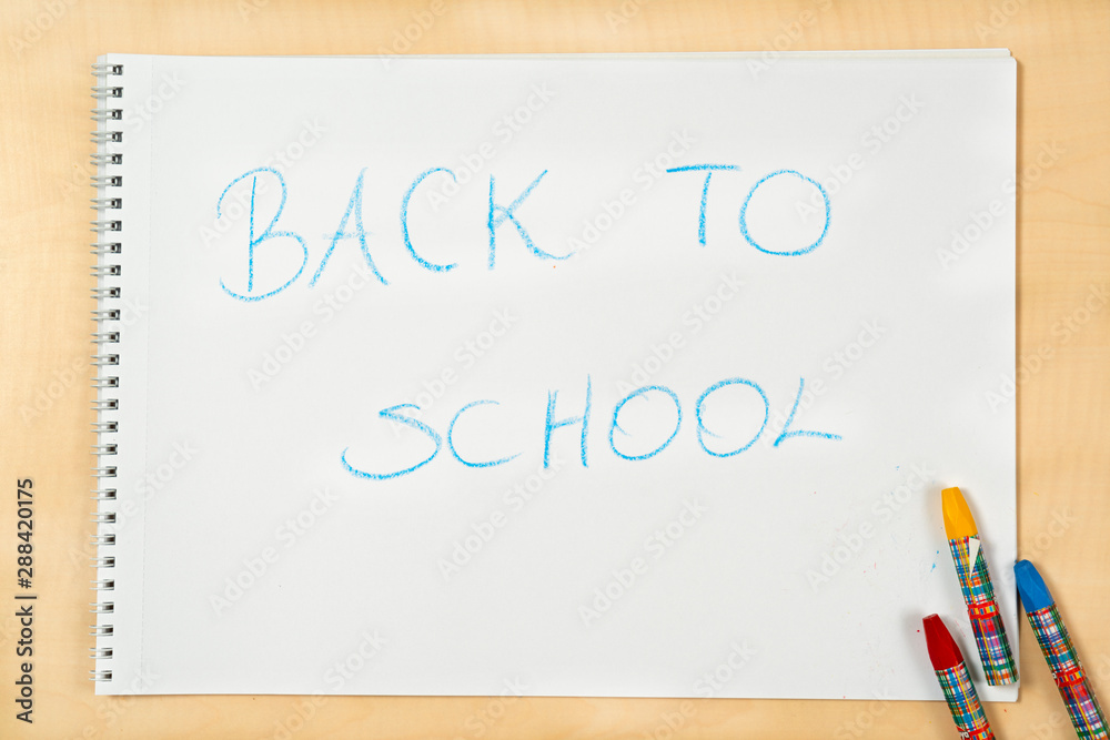 Blue color of back to school writing on notebook with color pencil - Top view Blue color of back to school writing on notebook with color pencil - Top view