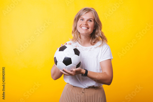 Screaming young blonde woman, with rised hands, celebrating over yellow wall © Vulp