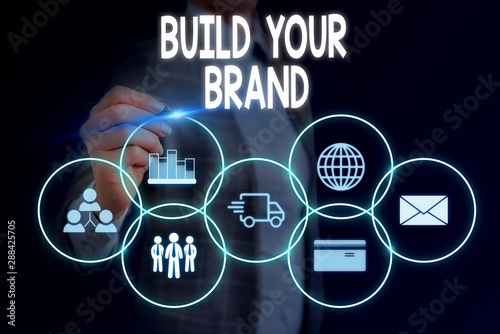 Word writing text Build Your Brand. Business photo showcasing enhancing brand equity using advertising campaigns Woman wear formal work suit presenting presentation using smart device