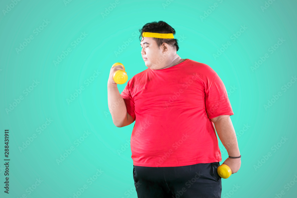 Asian fat man exercising his biceps with dumbbells Asian fat man exercising his biceps with dumbbells