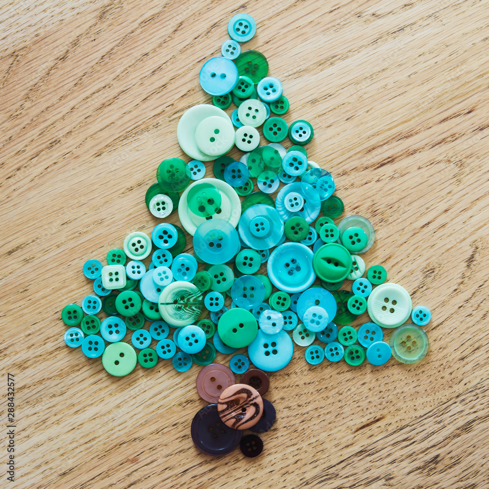 Blue and green buttons in a pile on a wooden surface in a shape of a ...