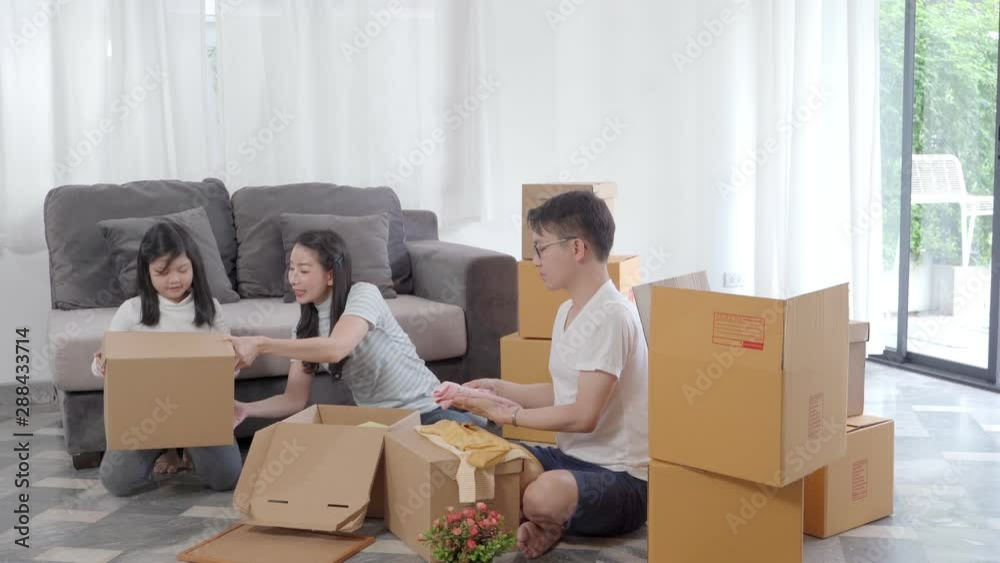 happy Asian family moving to new house with cardboard boxes and arrange the house. happy Asian family moving to new house with cardboard boxes and arrange the house.