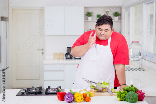Obese man thinking an idea in the kitchen