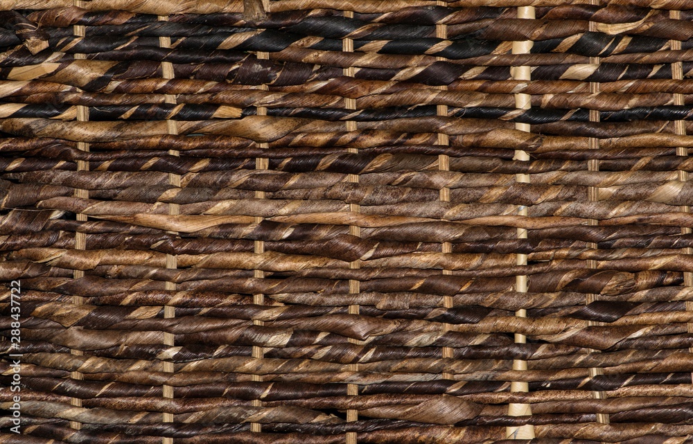 Dark wicker basket background texture with woven strands ranging from light brown to black. Dark wicker basket background texture with woven strands ranging from light brown to black.