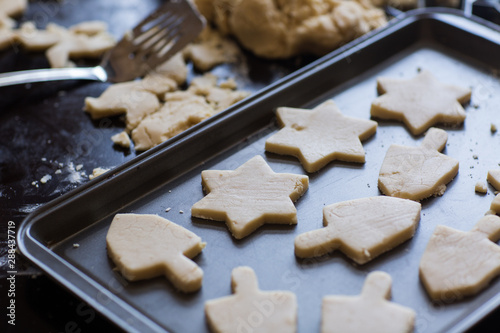 Hanukkah dreidel and star of David homemade cookie dough being cut