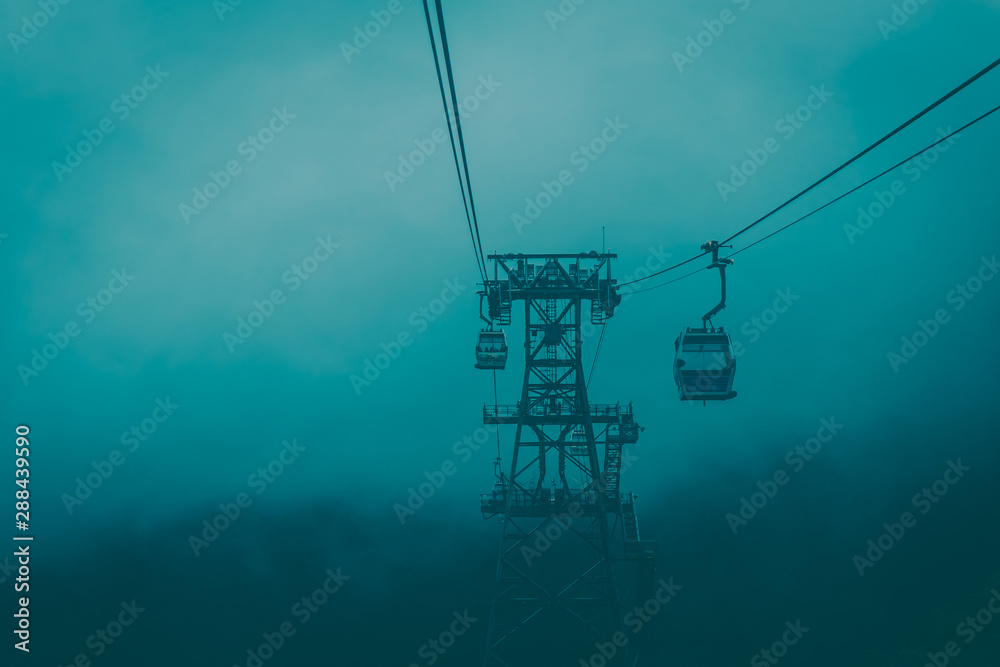 cable car through into fog on mountain. dramatic tone photo