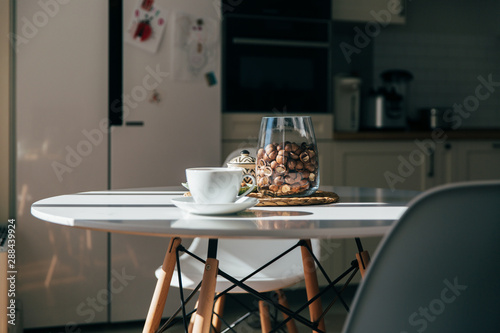 Bild auf Leinwand Macadamia nuts in a bowl and cup of tea or coffee stand in the kitchen table, ha