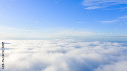 Aerial view White clouds in blue sky. Top view. View from drone. Aerial bird's eye view. Aerial top view cloudscape. Texture of clouds. View from above. Sunrise or sunset over clouds