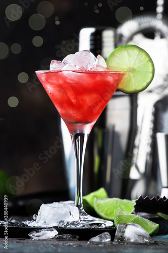 Watermelon cobler, alcoholic cocktail with vodka, lemon juice, mint, lime and crushed ice, metal bar tools, dark background photo